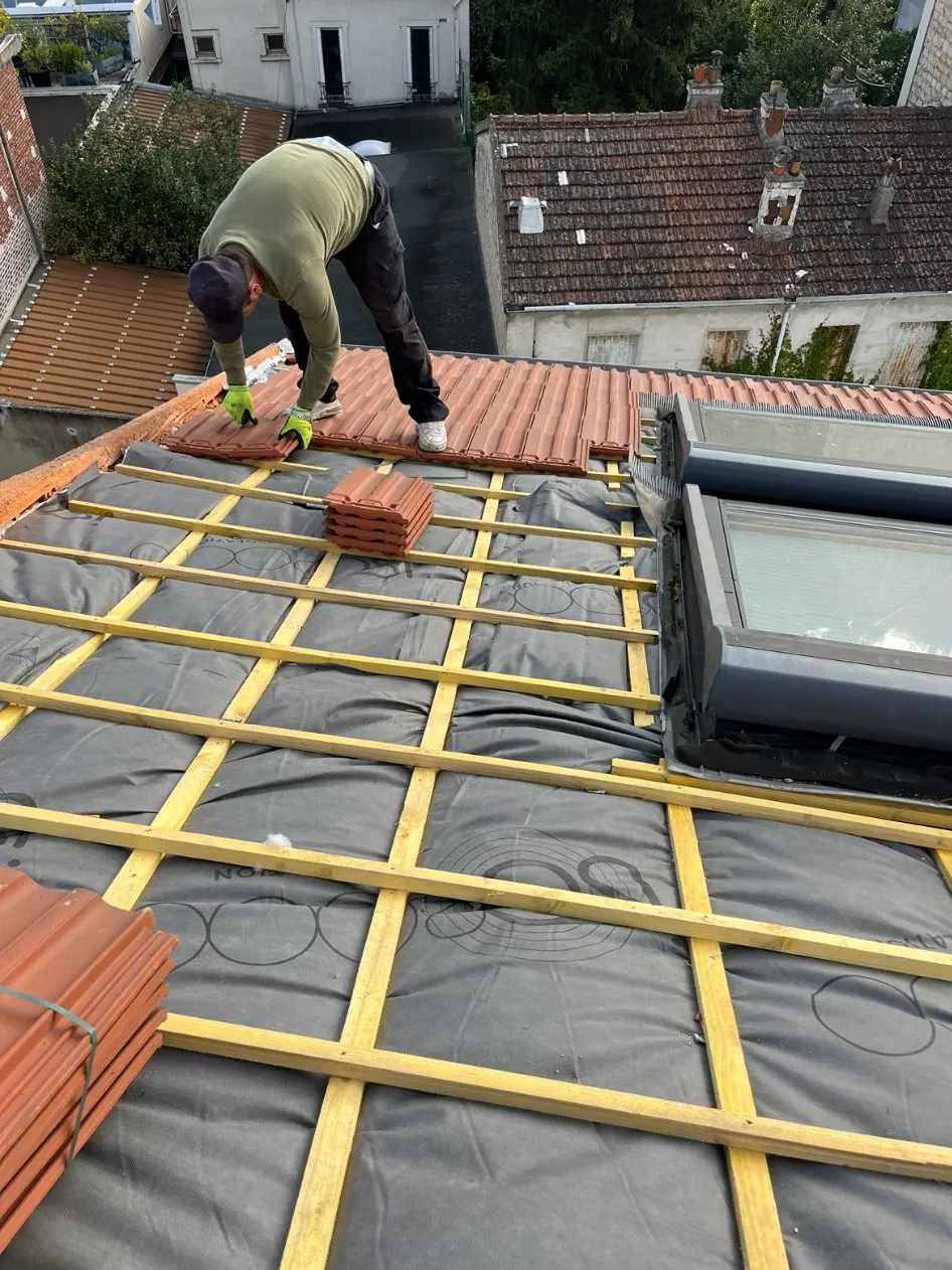 Pose de tuiles sur une toiture en rénovation